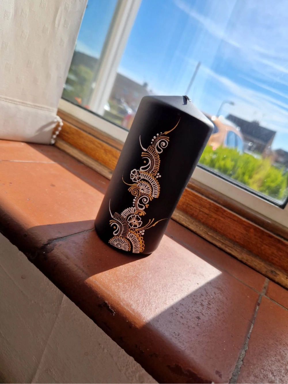Black pillar candle custom painted with white and gold paint